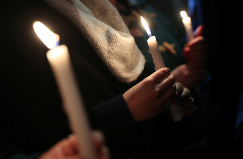 Anti-racism campaigners hold candles during a vigil, following the discovery of 39 bodies in a truck container on Wednesday, outside the Home Office in London, Britain October 24, 2019 (photo credit: REUTERS/HANNAH MCKAY)