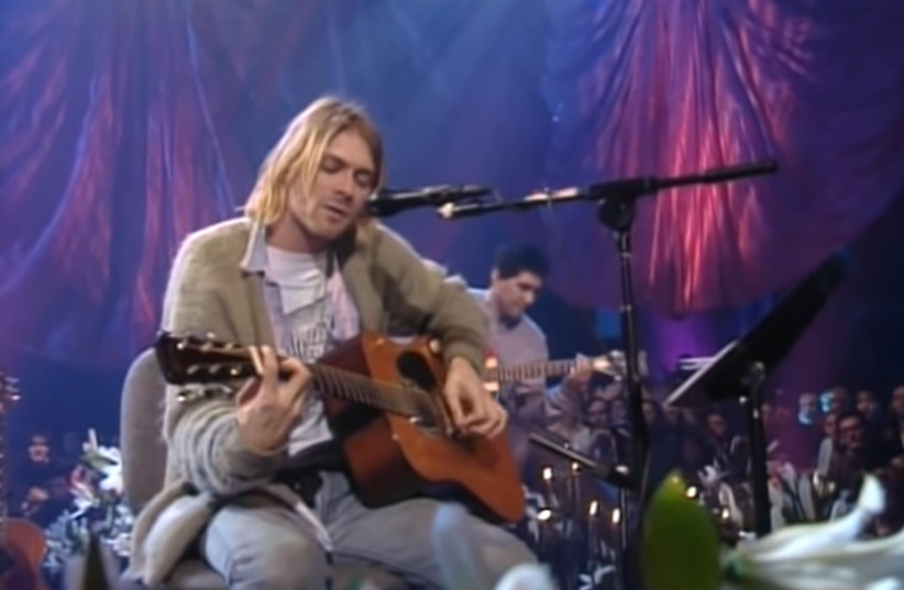Nirvana's Kurt Cobain plays in the now famous olive-green sweater on MTV Unplugged in 1993 (credit: screenshot)