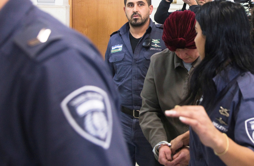 Malka Leifer, a former Australian school principal who is wanted in Australia on suspicion of sexually abusing students, walks in the corridor of the Jerusalem District Court accompanied by Israeli Prison Service guards, in Jerusalem (photo credit: REUTERS/Ronen Zvulun)