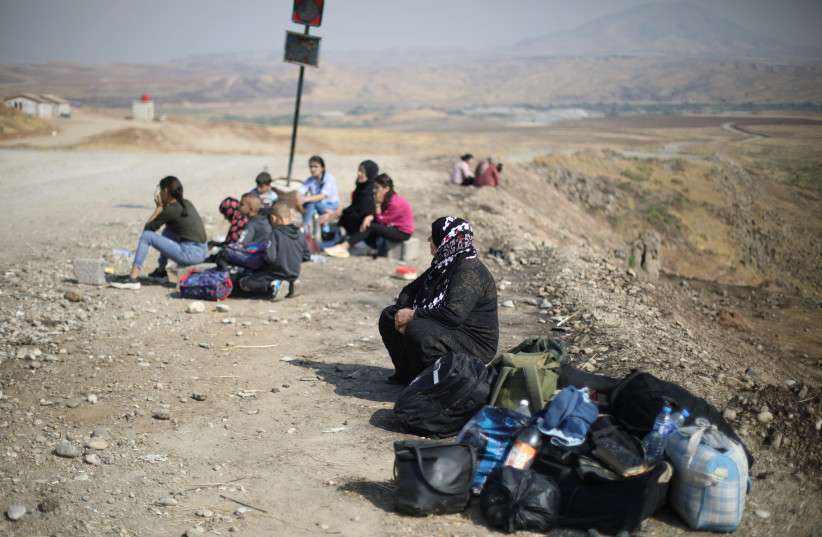 Displaced Kurds stuck at a border after a Turkish offensive in northeastern Syria, wait to try cross to the Iraqi side, at the Semalka crossing, next Derik city, Syria, October 21, 2019 (photo credit: REUTERS/MUHAMMAD HAMED)