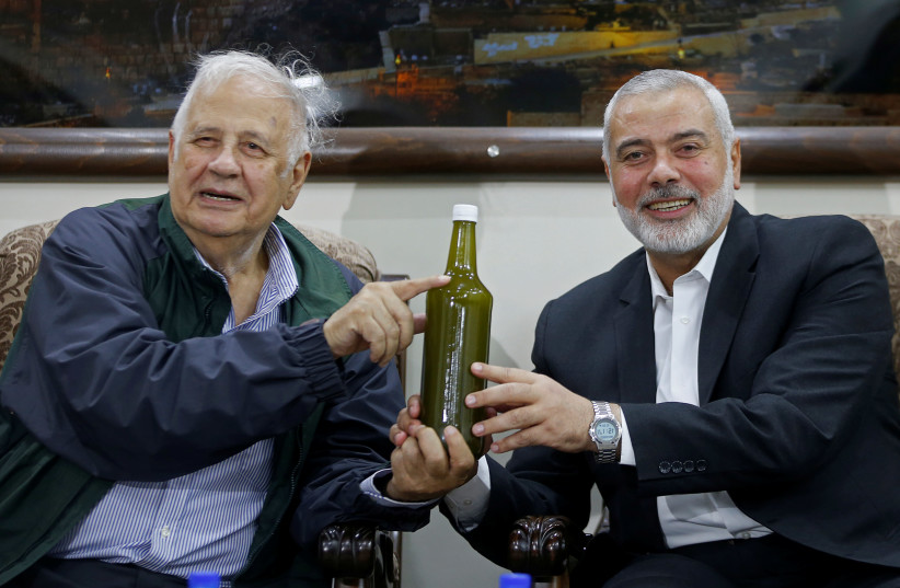 Palestinian Hamas Chief Ismail Haniyeh and Chairman of the Palestinian Central Election Committee Hana Naser hold a bottle of olive oil during their meeting in Gaza City October 28, 2019 (photo credit: REUTERS/MOHAMMED SALEM)