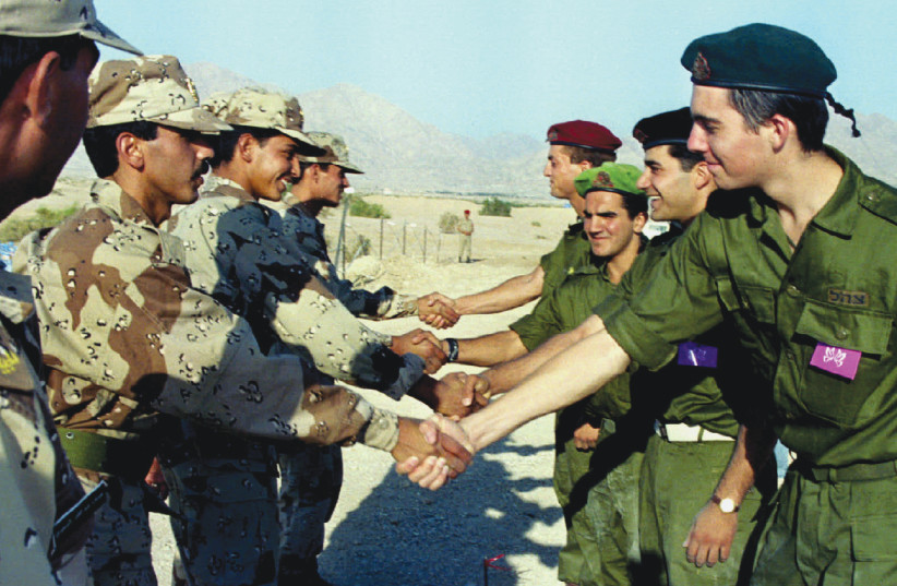 SRAELI AND Jordanian soldiers shake hands during a ceremony at the Wadi Araba border crossing June in 1995. (photo credit: REUTERS)