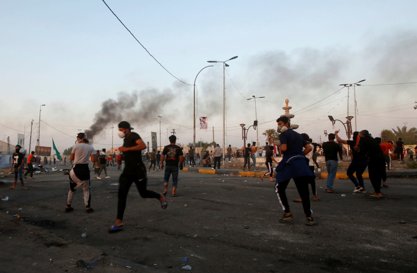 Demonstrators clash with members of Iraqi security forces during the ongoing anti-government protests near the Governorate building of Basra, Iraq November 8, 2019 (photo credit: ESSAM AL-SUDANI/ REUTERS)
