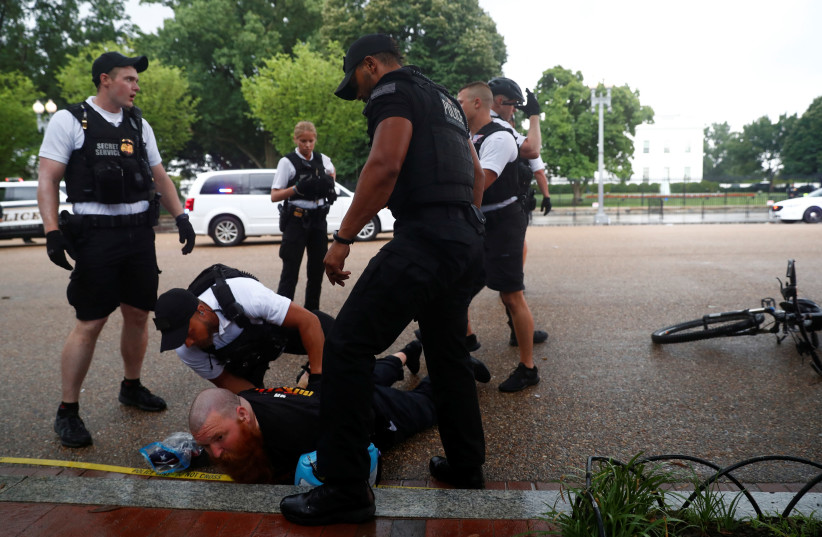 U.S. Secret Service Uniformed Division officers detain a man in front of the White House during a Fourth of July Independence Day protest in Washington, D.C., U.S. (photo credit: REUTERS/ERIC THAYER)