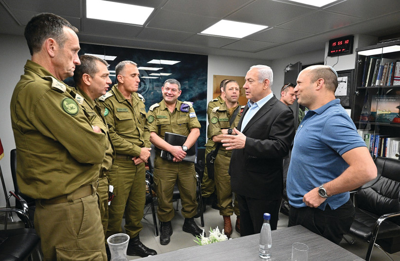 Prime Minister Benjamin Netanyahu [M] and Defense Minister Naftali Bennett [R] speaking with IDF officers  (photo credit: AMOS BEN-GERSHOM/GPO)