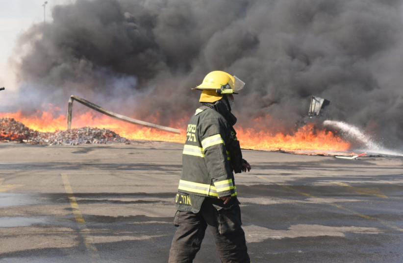 A firefighter walks past the flames at the Idan haNegev Industrial Park in Lehavim, near Beersheba (photo credit: FIRE AND RESCUE SERVICE SOUTHERN DISTRICT)