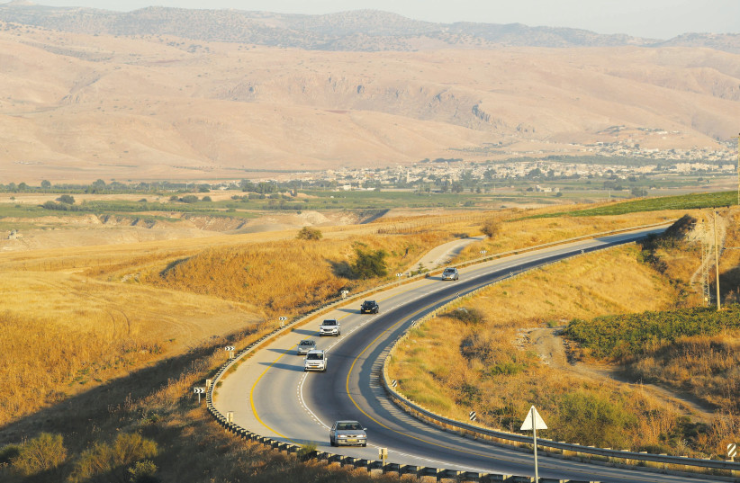 Vehicles drive along a road in the Jordan Valley  (photo credit: AMMAR AWAD/REUTERS)