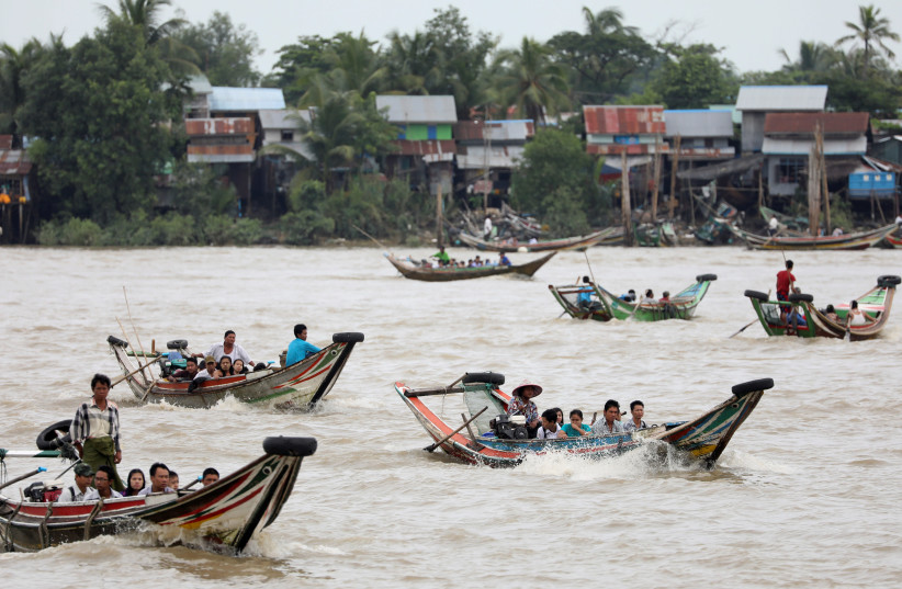 People living on the other side of the river, the site of the proposed New Yangon City project site, arrives for school and work by boat in the early morning in Yangon, Myanmar, August 2, 2019 (photo credit: ANN WANG / REUTERS)