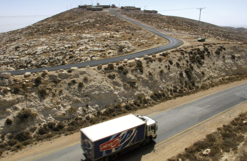 A TRUCK passes a small Israeli community in the West Bank (photo credit: REUTERS)