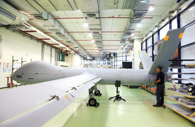 AN EMPLOYEE stands next to an Elbit Systems Ltd. Hermes 900 unmanned aerial vehicle at the company's drone factory in Rehovot (photo credit: REUTERS/OREL COHEN)