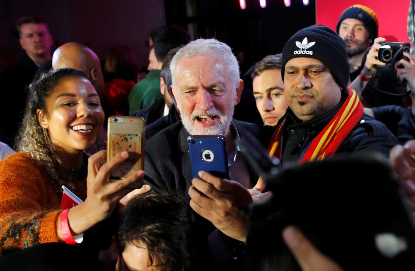 Britain's opposition Labour Party leader Jeremy Corbyn poses for photos with supporters during a general election campaign rally in Birmingham, Britain December 5, 2019 (photo credit: PHIL NOBLE/REUTERS)