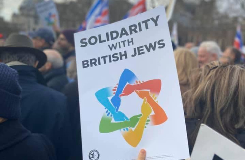 Demonstrator holds up sign reading "Solidarity with British Jews" at "Together Against Antisemitism" rally in London (photo credit: SARKIS ZERONIAN)