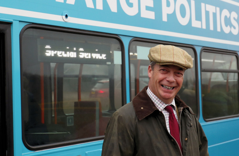 Brexit Party leader Nigel Farage stands outside his battle bus during an election campaign event in Easington, Britain, on November 24 (photo credit: REUTERS)
