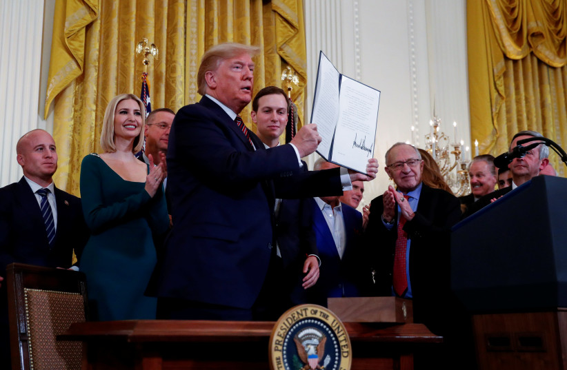 White House senior advisors Ivanka Trump and Jared Kushner, New England Patriots owner Robert Kraft and others stand behind U.S. President Donald Trump as he holds up an executive order on anti-semitism that he signed during a Hanukkah reception in the East Room of the White House in Washington, U.S (photo credit: REUTERS//TOM BRENNER)