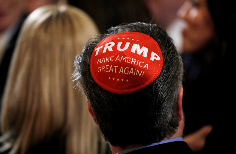 A participant wears a Trump "Make America Great Again" yarmulke as they attend a White House Hanukkah reception where U.S. President Donald Trump signed an executive order on anti-semitism in the East Room of the White House in Washington, U.S. (photo credit: REUTERS/TOM BRENNER)