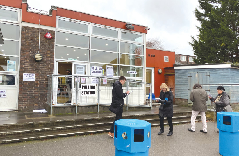 VOTERS AND TELLERS outside of polling station inside Menorah Primary School in Golders Green, London (photo credit: JOSH DELL)