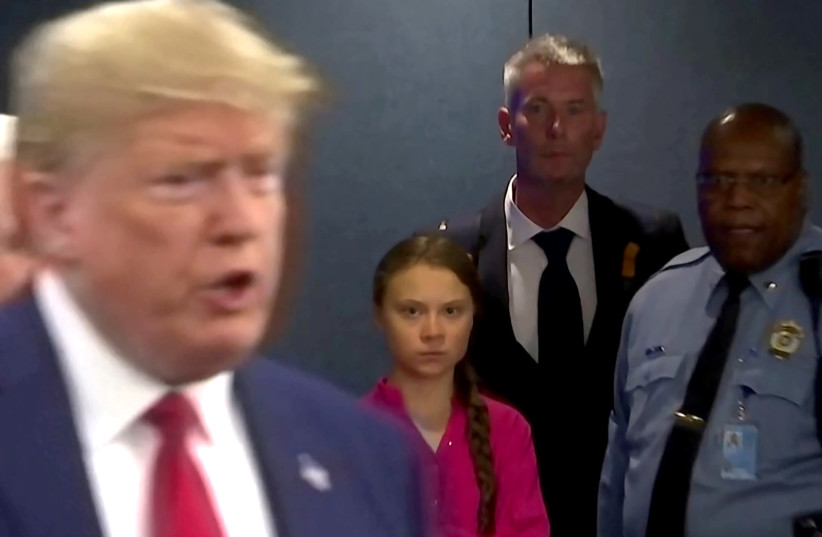Swedish environmental activist Greta Thunberg watches as U.S. President Donald Trump enters the United Nations to speak with reporters (photo credit: REUTERS/ANDREW HOFSTETTER)