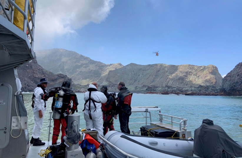 Members of a dive squad conduct a search during a recovery operation around White Island, which is also known by its Maori name of Whakaari, a volcanic island that fatally erupted earlier this week, in New Zealand, December 13, 2019 (photo credit: NEW ZEALAND POLICE/VIA REUTERS)