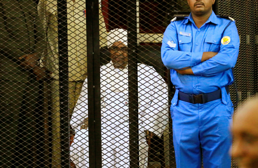Sudanese former president Omar Hassan al-Bashir sits inside a cage during the hearing of the verdict that convicted him of corruption charges in a court in Khartoum, Sudan. December 14, 2019 (photo credit: REUTERS/MOHAMED NURELDIN ABDALLAH)