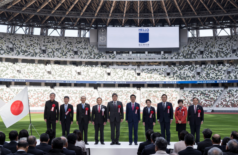People pose during a group photograph during the construction completion ceremony of the New National Stadium on December 15, 2019 in Tokyo, Japan. Seen here are (L-R) Architect Kengo Kuma, Azusa Sekkei Co. President Fumihiko Sugitani, Taisei Corp. Chairman Takashi Yamauchi, Japan Sport Council Pres (photo credit: TOMOHIRO OHSUMI/POOL VIA REUTERS)