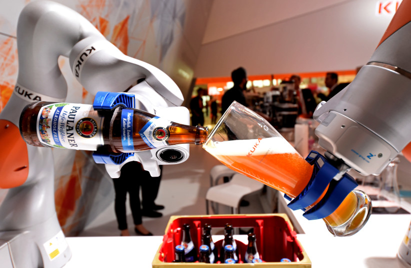 A robotic arm fills a glass with Bavarian Weiss beer at the booth of German company Kuka at the world's biggest industrial fair (photo credit: REUTERS)