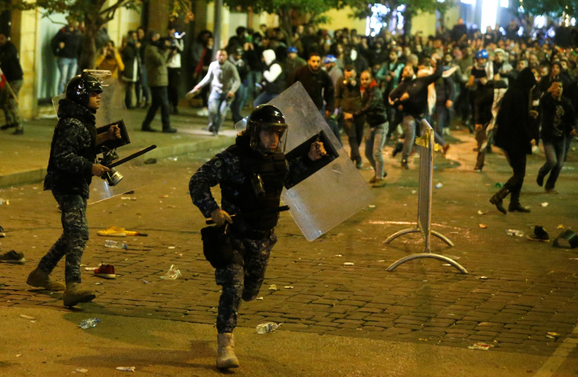 A riot police runs for cover during anti government protests in Beirut, Lebanon (photo credit: REUTERS/MOHAMED AZAKIR)
