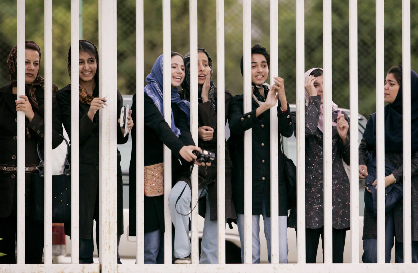 Iranian women watch the practice session of Iran's national soccer team from behind the railings as they banned from entering the stadium at Azadi (freedom) sport complex in Tehran, Iran May 21, 2006 (photo credit: MORTEZA NIKOUBAZI/ REUTERS)