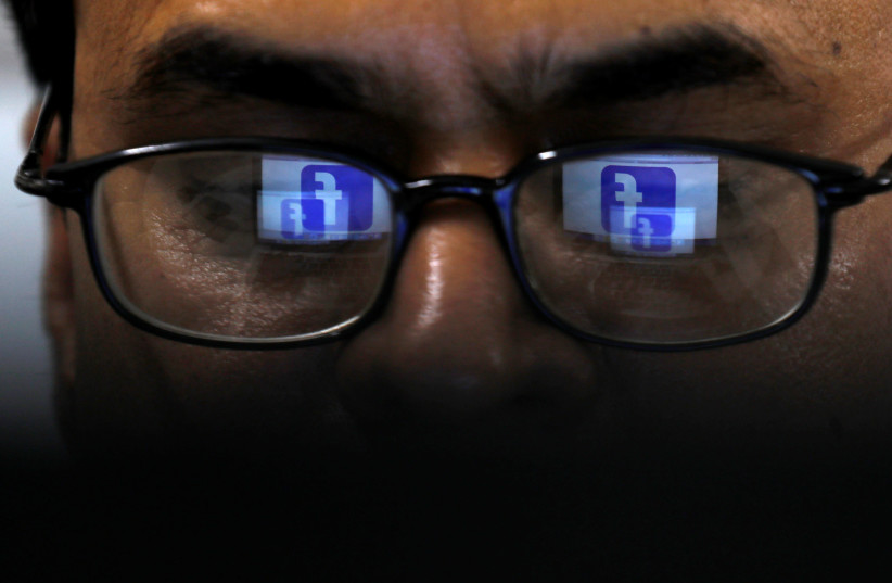 Facebook logo is reflected in glasses in this picture illustration taken April 1, 2019 (credit: REUTERS/AKHTAR SOOMRO/ILLUSTRATION)