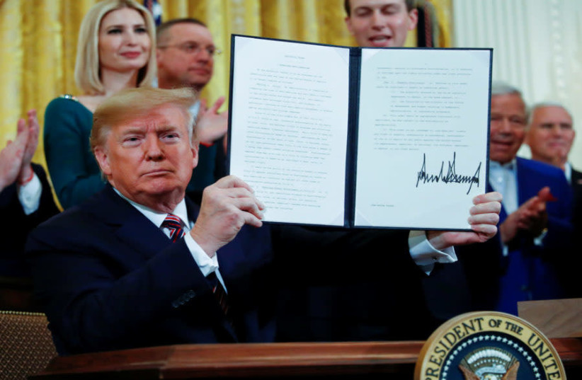 US President Donald Trump signs an executive order adopting the internationally recognized definition of anti-Semitism at the White House Hanukkah party in December 2019. (photo credit: Wikimedia Commons)