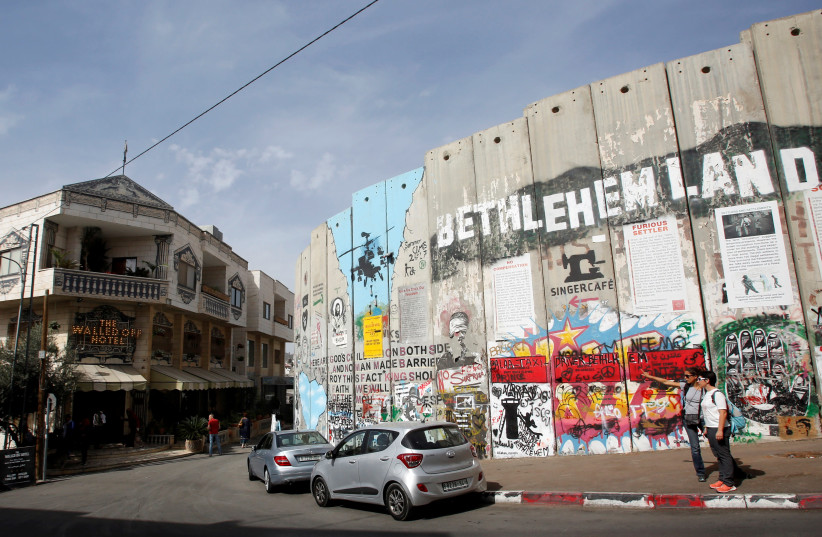 A view shows Banksy's the Walled Off hotel and a section of the Israeli barrier in Bethlehem, October 23, 2018. (photo credit: MUSSA QAWASMA/REUTERS)