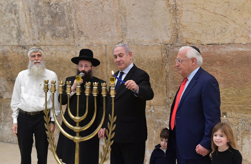 Prime Minister Benjamin Netanyahu lighting a candle for the first night of Hanukkah   (photo credit: KOBI GIDEON/GPO)