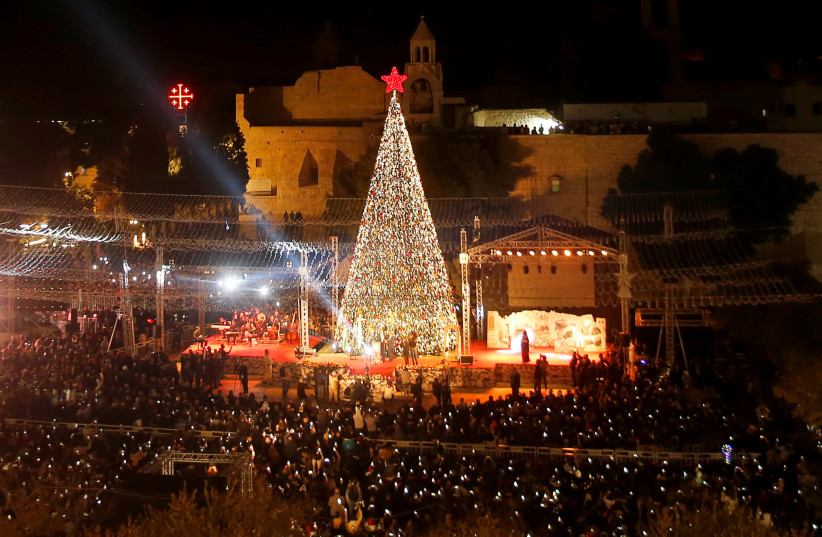 Palestinians light Christmas tree in Manger Square outside the Church of the Nativity in Bethlehem, November 30, 2019 (credit: REUTERS/MUSSA QAWASMA)