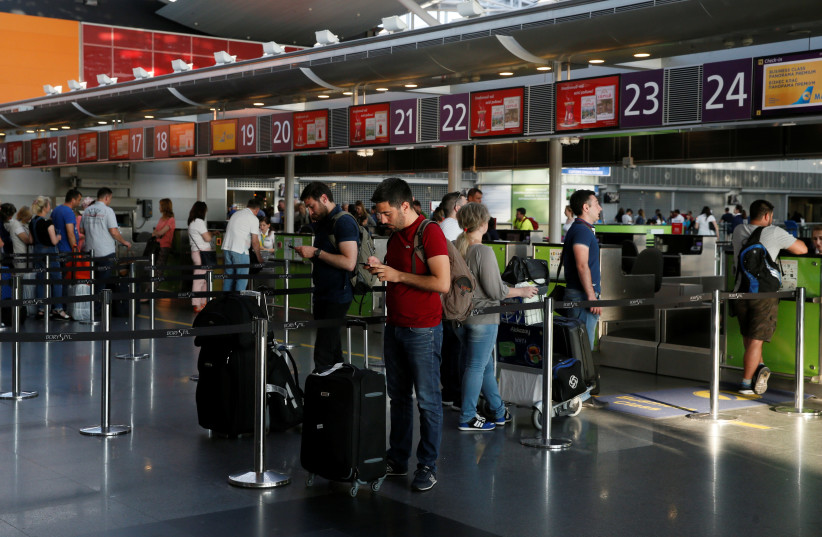 Passengers wait to have their luggage checked at Boryspil airport in Ukraine (photo credit: VALENTYN OGIRENKO/REUTERS)