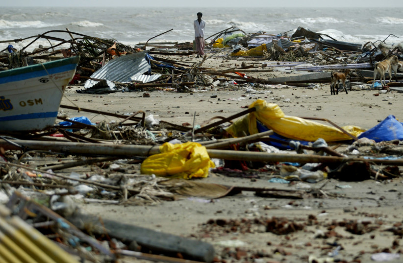 An Indian man walks among debris left behind after a tsunami hit Velankani beach on the outskirts of Nagapattinam, south of the Indian city of Madras, December 28, 2004 (photo credit: PUNIT PARANJPE / REUTERS)