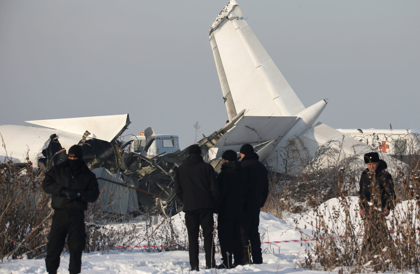 Emergency and security personnel are seen at the site of a plane crash near Almaty, Kazakhstan, December 27, 2019. (photo credit: REUTERS/PAVEL MIKHEYEV)