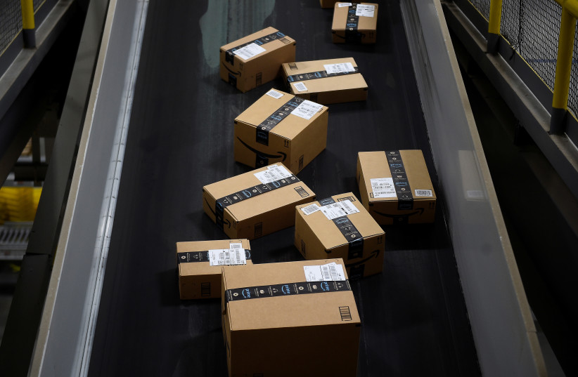 Boxes ready to be loaded onto a delivery truck move along a conveyor belt at the Amazon fulfilment centre in Baltimore (photo credit: REUTERS)