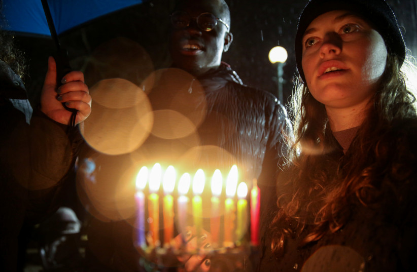 A woman holds candles while standing in solidarity with the victims after an assailant stabbed five people attending a party at an Hasidic rabbi's home in Monsey, N.Y., on December 28, 2019, (photo credit: REUTERS/AMR ALFIKY)