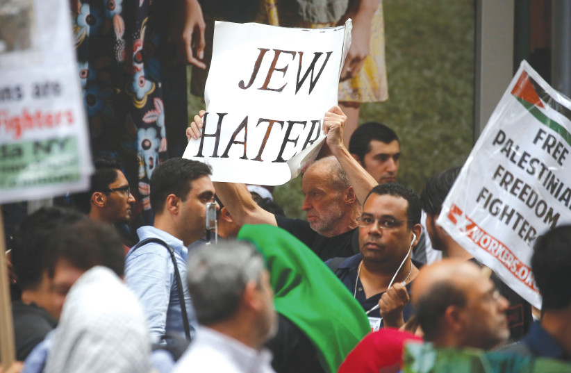 A MAN with a sign accuses others of being anti-Jewish at a rally in New York City. (photo credit: REUTERS)