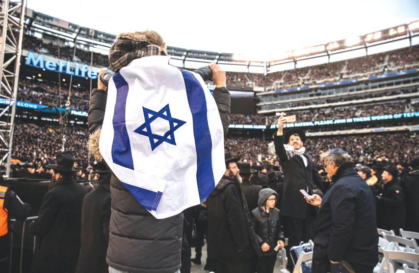 JEWS SING and dance during the 13th Siyum HaShas at the MetLife Stadium in East Rutherford, New Jersey, on January 1. (photo credit: JEENAH MOON/REUTERS)