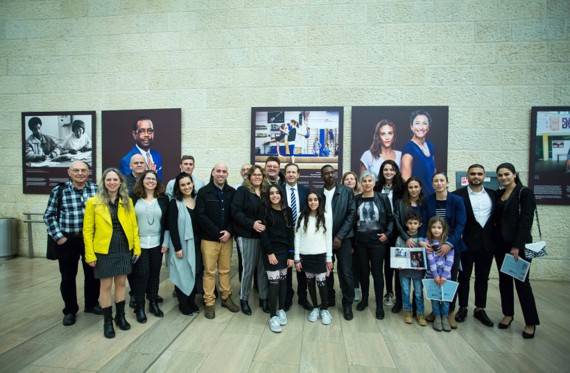 Jewish Agency Chairman Isaac Herzog and CEO Amira Ahronoviz (center) with subjects of the exhibit at Ben Gurion. (photo credit: DROR SITHAKOL​)