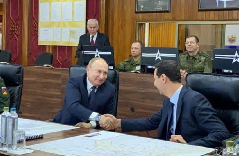 Russian President Vladimir Putin shakes hands with Syria's President Bashar al-Assad in Damascus, Syria in this handout released by SANA on January 7, 2020.  (photo credit: REUTERS)