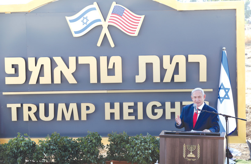 Prime Minister Benjamin Netanyahu speaks during a ceremony to unravel a sign for a new community named after US President Donald Trump in the Holan Heights last year. (photo credit: AMMAR AWAD / REUTERS)