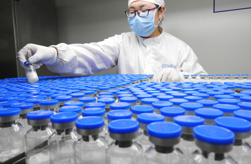 A technician inspects anti-cancer drugs in vials at a lab of a pharmaceutical company in Lianyungang, Jiangsu province, China March 13, 2019 (photo credit: REUTERS/STRINGER)
