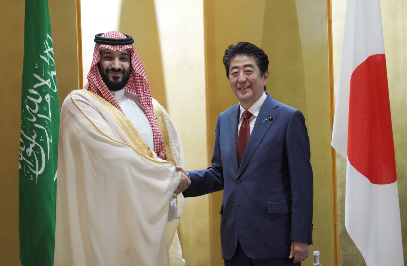 Saudi Arabia's Crown Prince Mohammed bin Salman, left, and Japanese Prime Minister Shinzo Abe, right, shake hands during their meeting in Osaka, western Japan Sunday, June 30, 2019. (photo credit: EUGENE HOSHIKO/POOL - REUTERS)