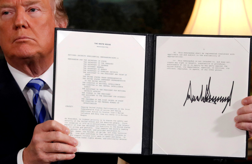 U.S. President Donald Trump holds up a proclamation declaring his intention to withdraw from the JCPOA Iran nuclear agreement after signing it in the Diplomatic Room at the White House in Washington (photo credit: REUTERS/JONATHAN ERNST)