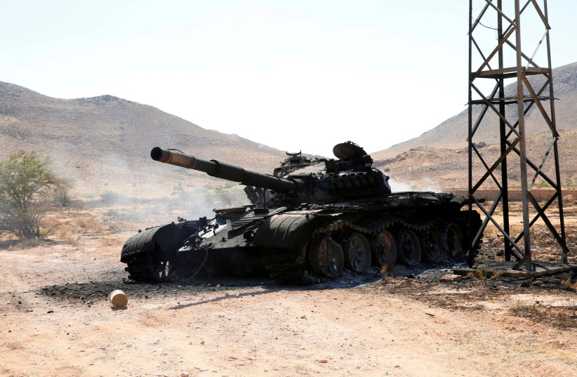 FILE PHOTO: A destroyed and burnt tank that belonged to the eastern forces led by Khalifa Haftar, is seen in Gharyan south of Tripoli Libya June 27, 2019. (photo credit: REUTERS/ISMAIL ZITOUNY)