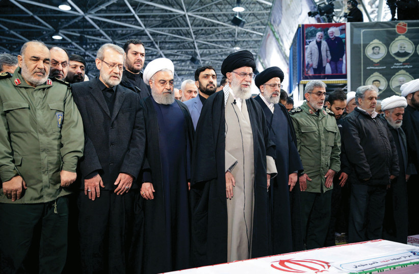 IRAN’S SUPREME LEADER Ayatollah Ali Khamenei and President Hassan Rouhani pray near the coffin of Qassem Soleimani in Tehran, last week. (photo credit: REUTERS)