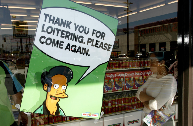 A poster with "The Simpsons" character Apu Nahasapeemapetilon, Jr., proprietor of the Springfield Kwik-E-Mart, is displayed on the window of a 7-Eleven convenience store in Burbank, California, July 2, 2007. (photo credit: REUTERS)