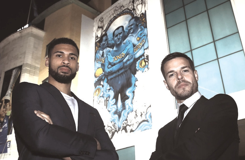 Chelsea players Ruben Loftus-Cheek (left) and Cesar Azpilicueta (right) and stand in front of the club’s mural commemorating Holocaust victims last week in London (photo credit: CHELSEA FC/COURTESY)