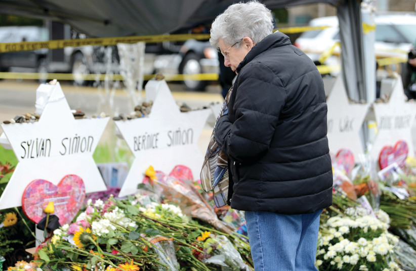 A visitor views a makeshift memorials outside the Tree of Life synagogue  in Pittsburgh, in 2018. (photo credit: ALAN FREED/REUTERS)